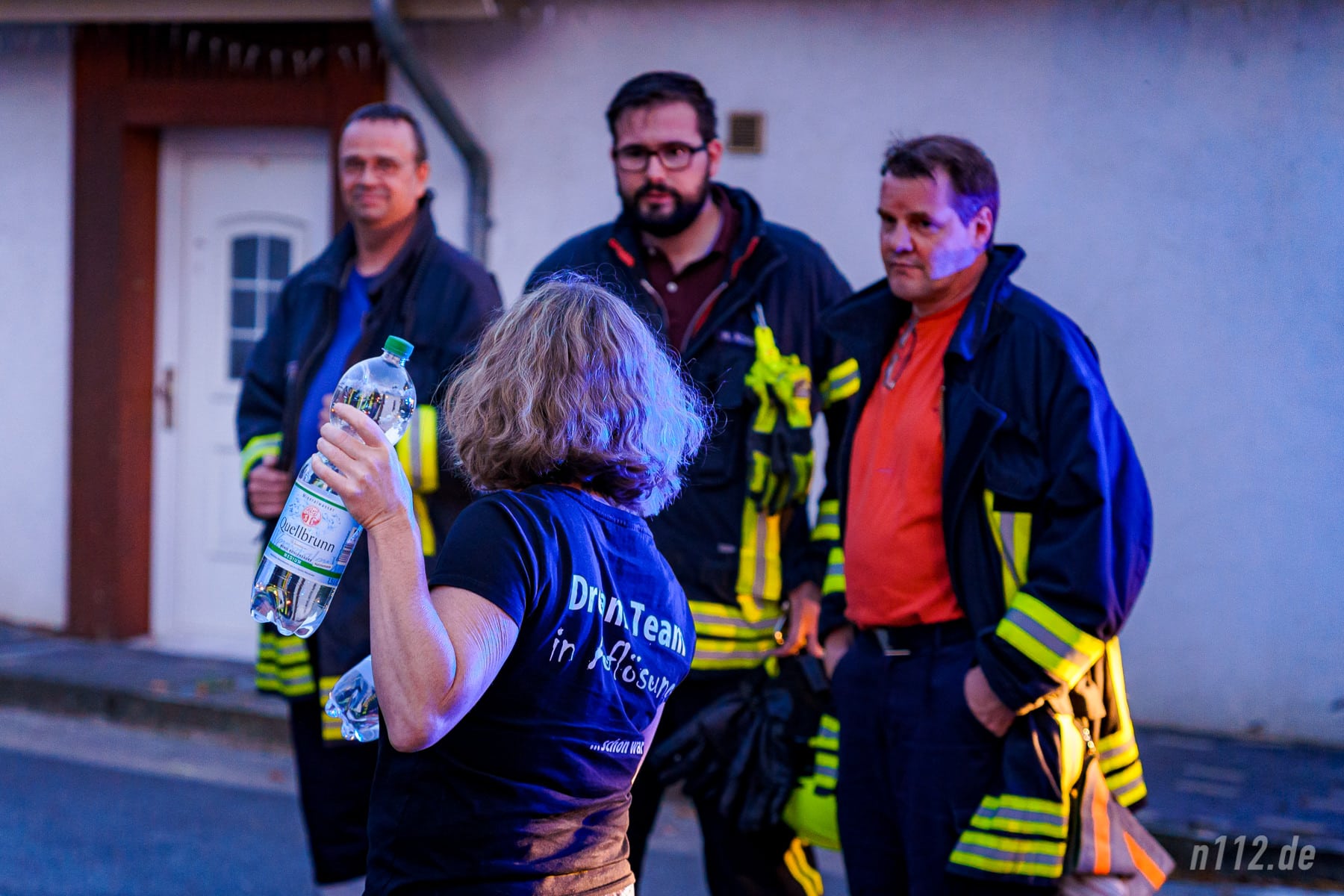 Eine Anwohnerin verteilt Wasserflaschen an die Feuerwehrleute (Foto: n112.de/Stefan Hillen)