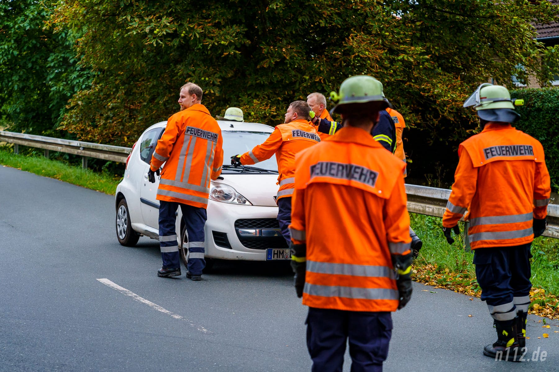 Ehrenamtliche Helfer schieben das Auto von der Straße, nachdem sie die Batterie abgeklemmt haben. (Foto: n112.de/Stefan Hillen)