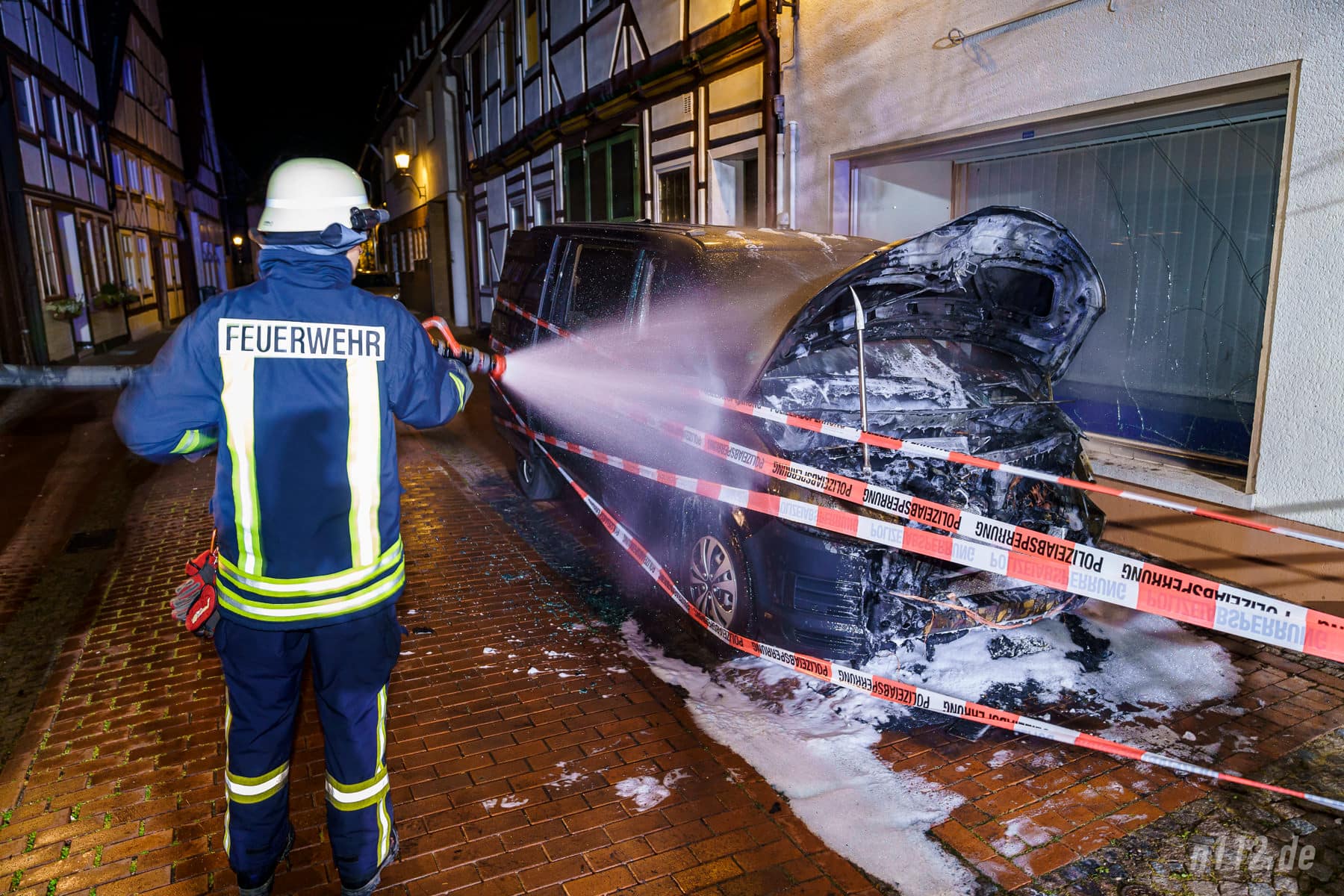 Letzte Glutnester werden mit Wasser gelöscht, nachdem die Polizei das Fahrzeug schon großzügig mit Absperrband eingewickelt hat (Foto: n112.de/Stefan Hillen)